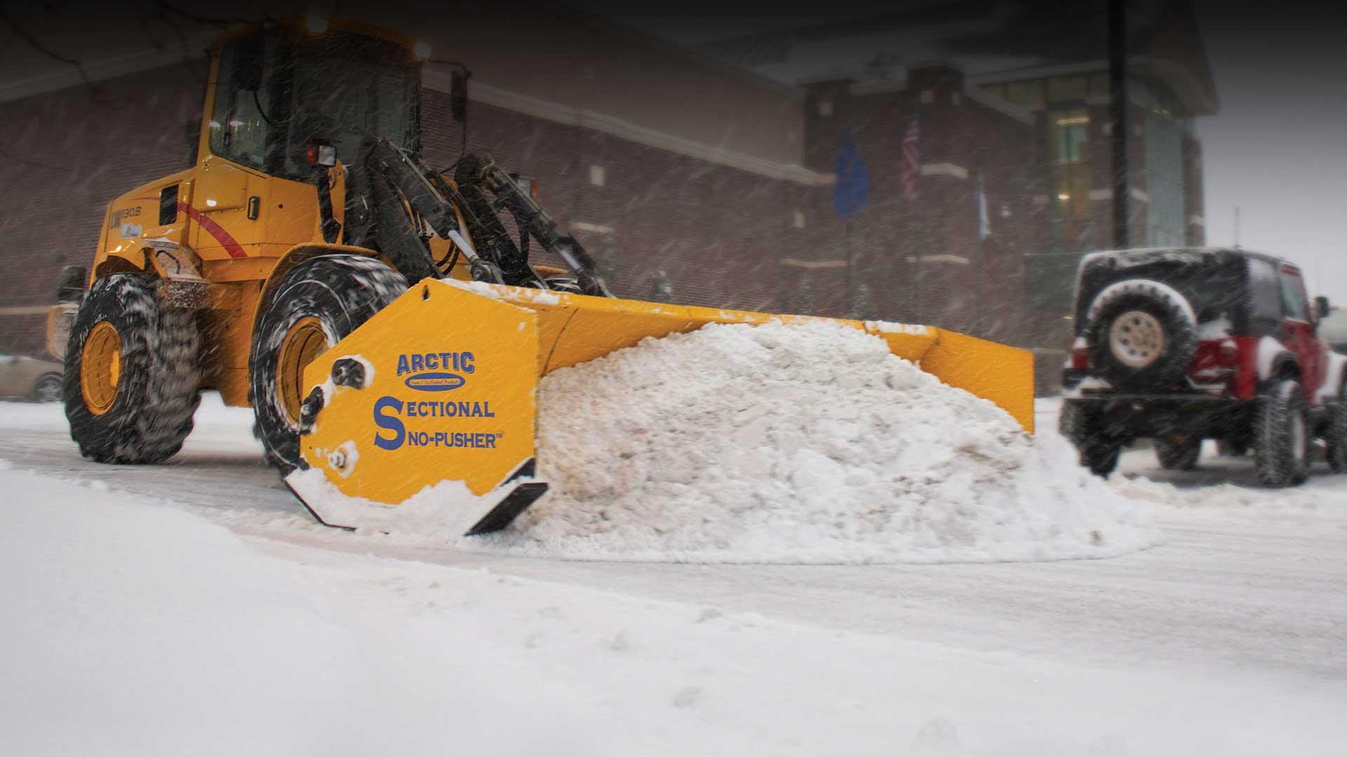 Arctic sectional Sno-Pusher moving snow