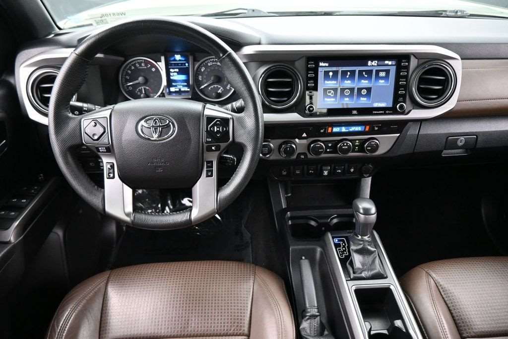 Cockpit and dashboard of a used 2021 Toyota Tacoma with touchscreen and leather seats