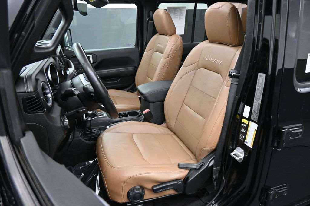 Front seats of a used 2022 Jeep Wrangler Unlimited in saddle leather