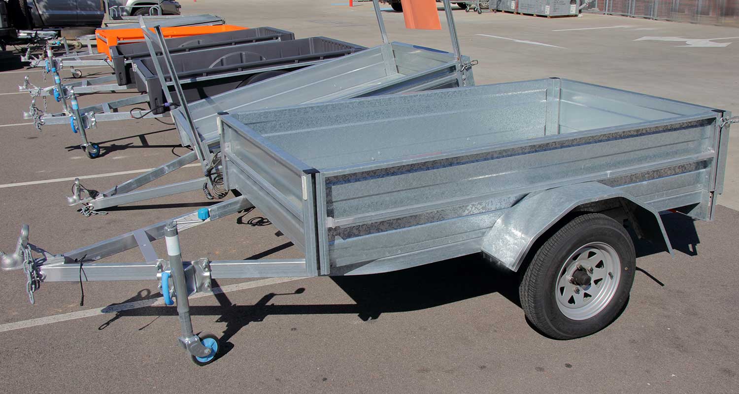 A row of car hauler trailers in a parking lot.
