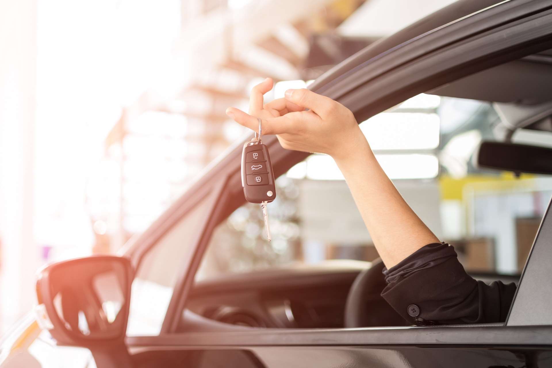 woman holding keys to her car thinking about selling