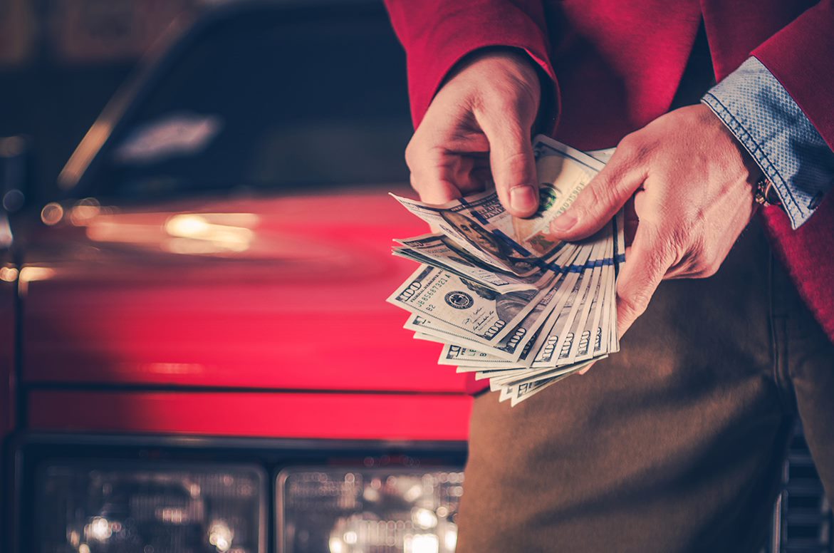 man paying for a car in cash